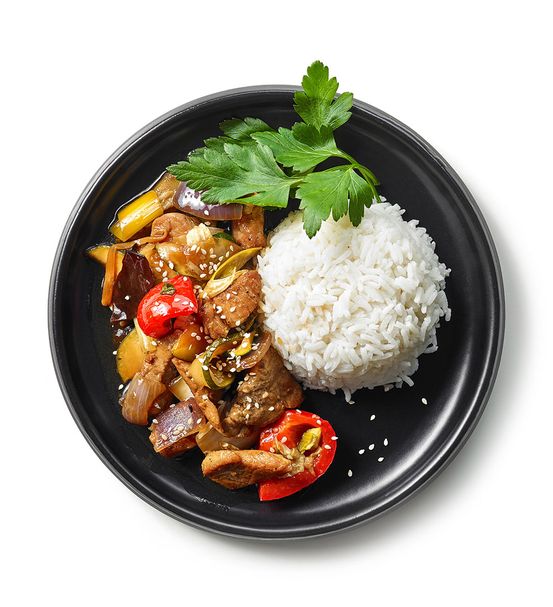 Plate of asian food, rice with meat and vegetables isolated on white background, top view